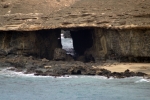 Арка, которую сделали волны на западном берегу острова Фуэртевентура. Издали грот на пляже Гарсей выглядит как дырка в скале.